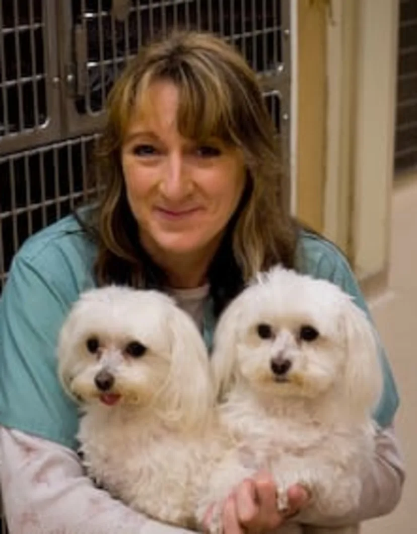 Mary holding 2 small white dogs